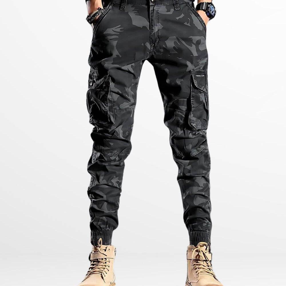 Man modeling slim fit camo cargo pants with cinched ankles paired with high-top golden boots.