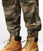 Green baggy camo cargo pants neatly tucked into honey-colored boots, showcasing a military-inspired style.
