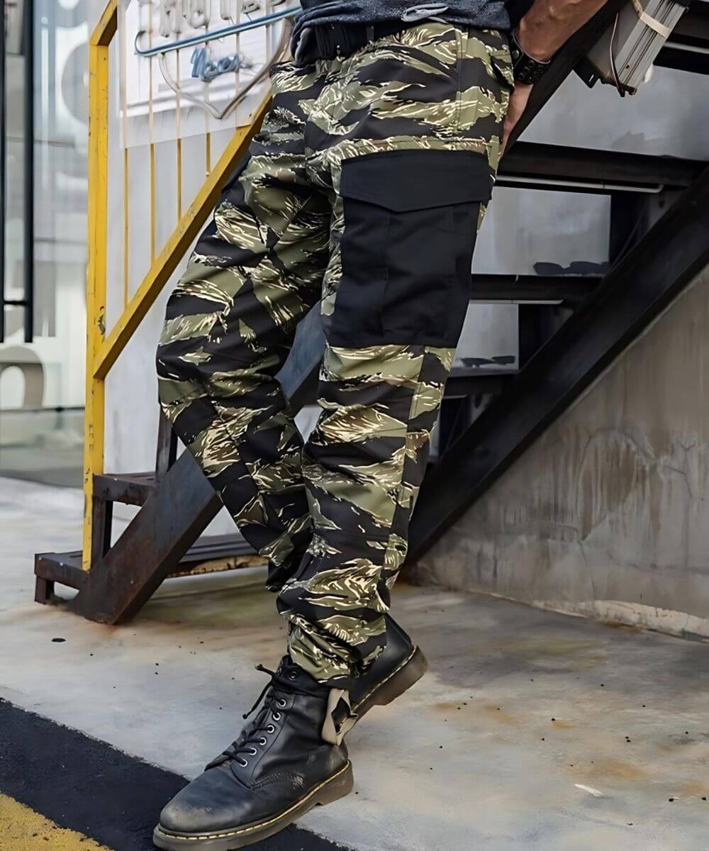 Action pose capturing the dynamic fit of Vietnam Tiger Stripe camouflage pants with detailed pocket and knee patch design.