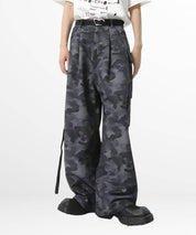 Front view of women's baggy camouflage pants featuring loose fit and stylish pockets, paired with a white belt and black boots.