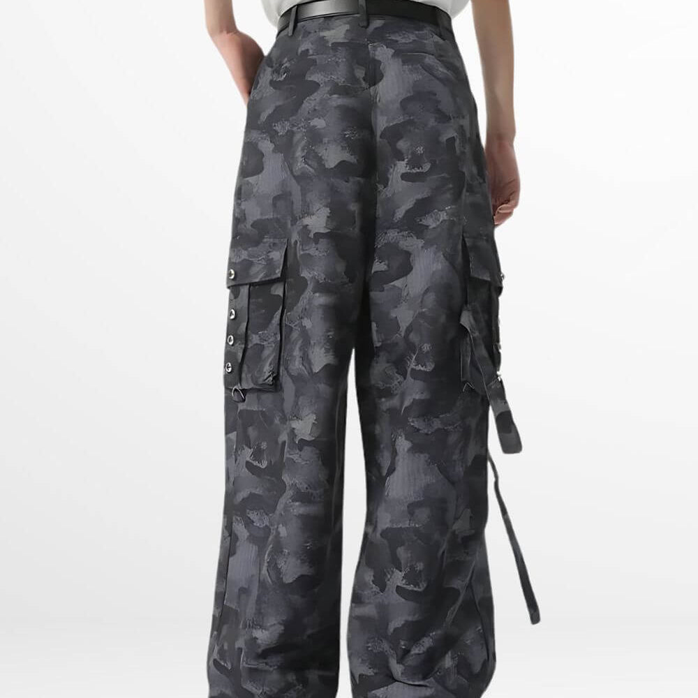 Side view of women's baggy camouflage pants highlighting cargo pocket details and a relaxed fit, paired with black boots.