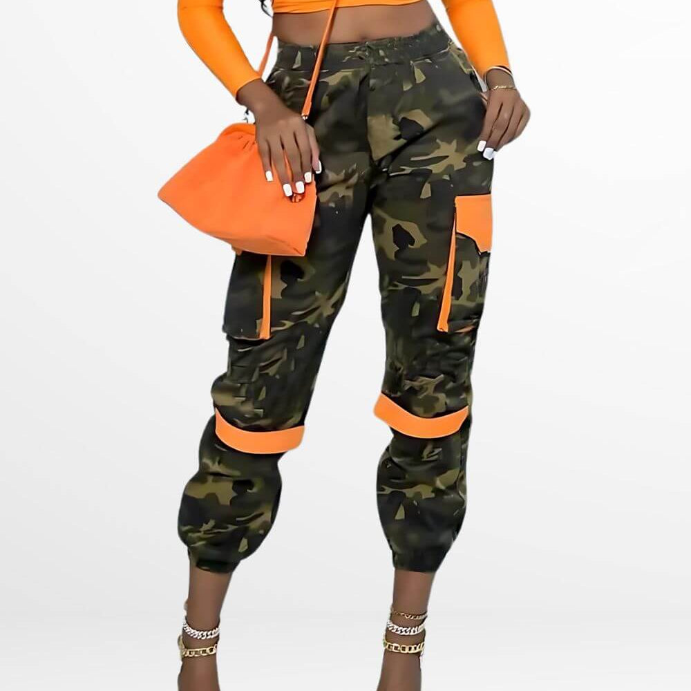 Fashionable women's camo pants with vibrant orange accents, styled with high heels and a matching clutch for a chic look.
