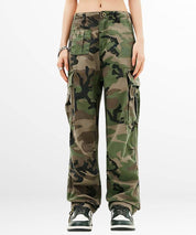 Full front view of women's green camouflage cargo pants with multiple pockets and stylish sneakers.