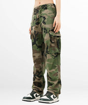 Side view of women's green camouflage cargo pants with cargo pocket details and trendy sneakers.