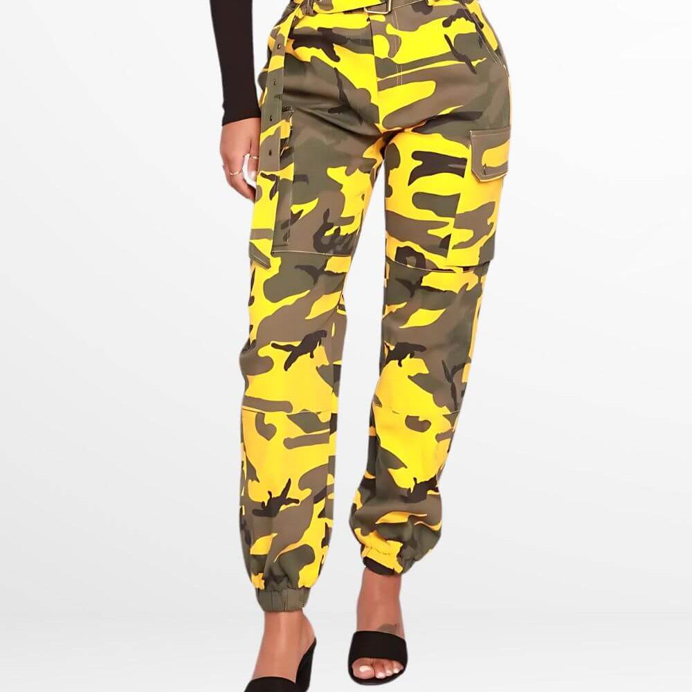 Front view of a woman wearing yellow camo pants with a high-rise waist and open-toe black heels.