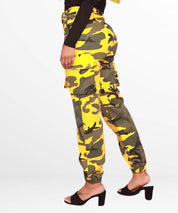 Side view of a woman in yellow camo pants showing the cargo pocket details and a black high-heel sandal.
