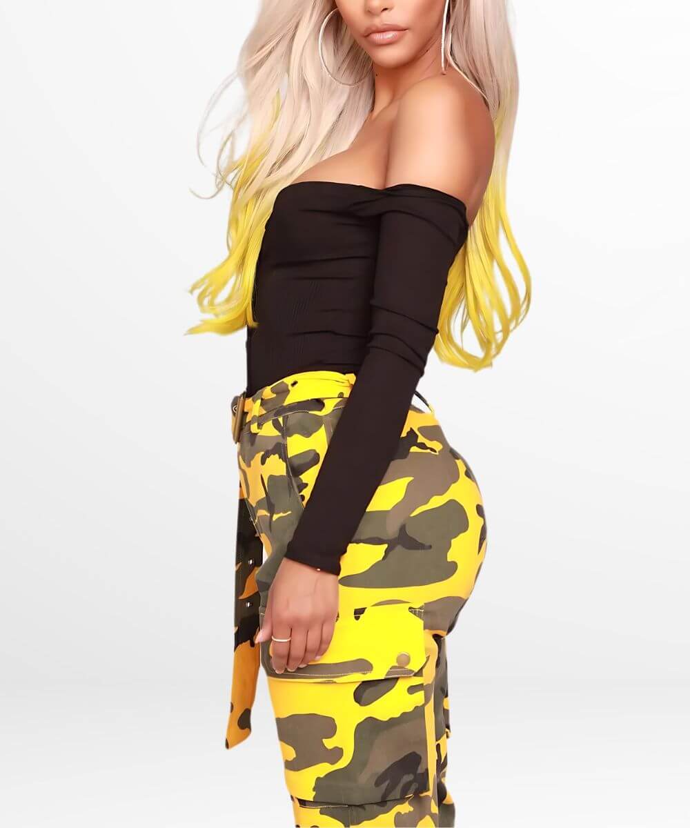 Three-quarter rear view of a woman showcasing the fit of yellow camo pants with a tied waist belt.